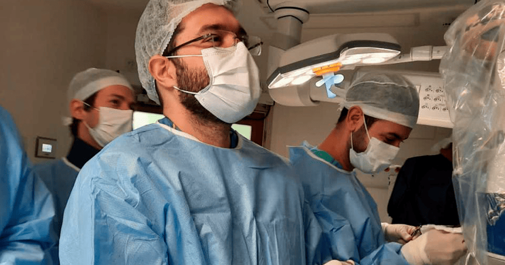 Médico realizando o procedimento de cirurgia nas costas